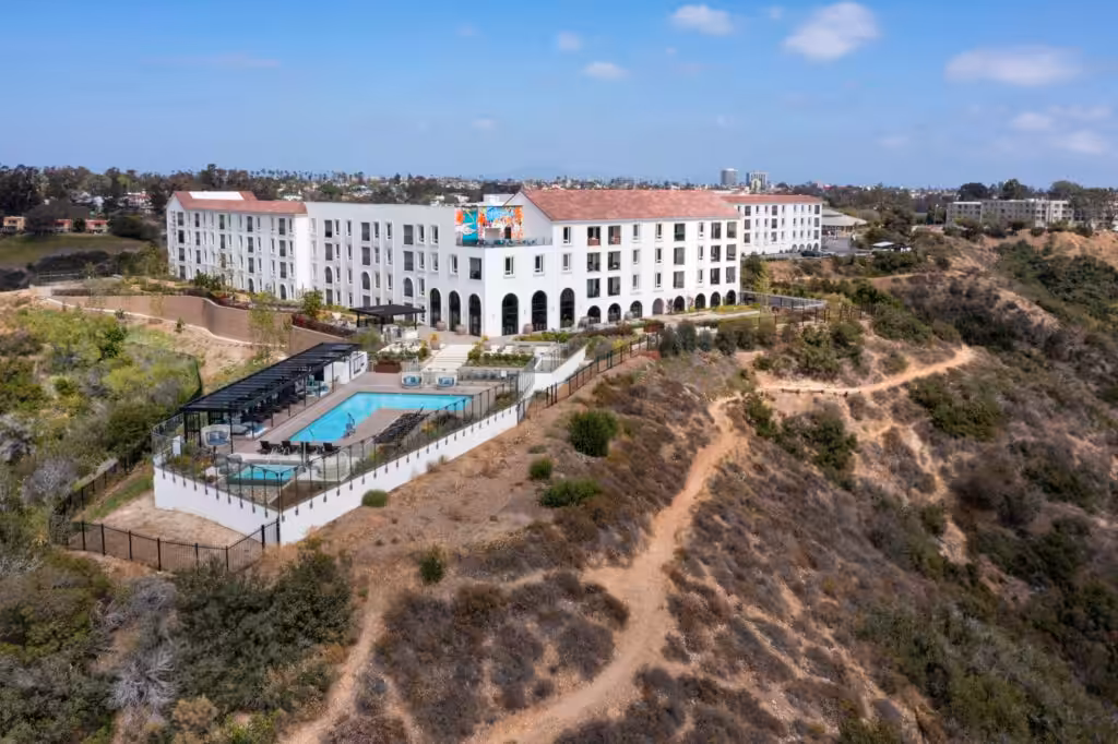 Drone hero shot of Camden Hillcrest composed to show the building within its surrounding setting